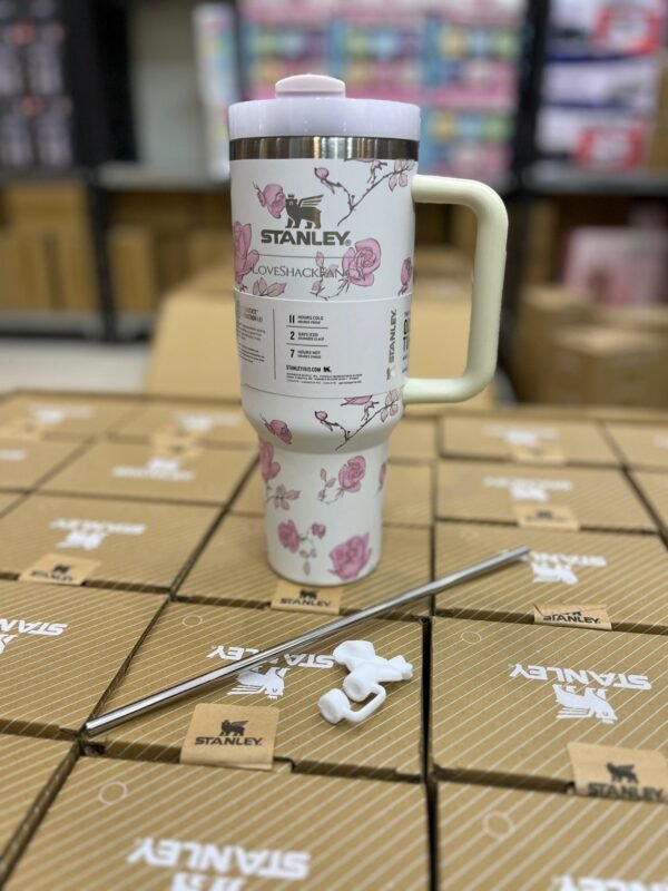 White floral print tumbler with handle and a straw beside it
