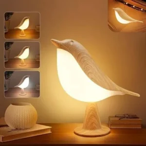 Bird-shaped night lamp with a wood-grain finish glowing warm white on a table