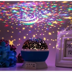 Rotating star projector lamp with a blue base casting coloured stars on a wall