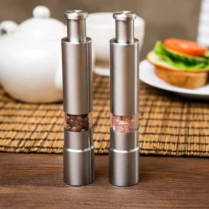 Stainless steel push-button spice grinders with clear windows showing peppercorns and salt
