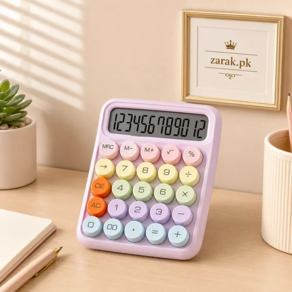 Pink pastel calculator with round coloured keys on a desk beside a small plant