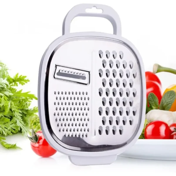 4-in-1 vegetable grater with its clear lid and handle beside fresh tomatoes and herbs
