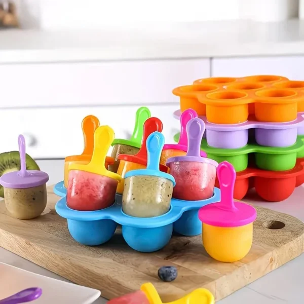 Blue, purple and orange silicone popsicle molds filled with colourful treats on a board