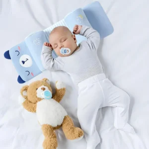 Sleeping baby with a pacifier lying on the blue bear-print baby head pillow with rolled sides