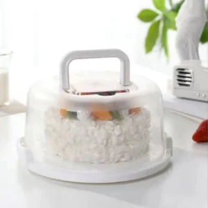 Clear dome cake carrier with a white base and handle holding a frosted cake