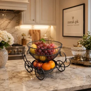 Black wire carriage-shaped two-tier fruit basket with grapes and oranges on a marble counter