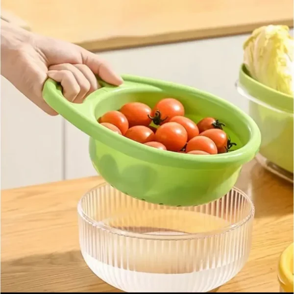 Hand tilting a green colander basket of tomatoes over a clear bowl