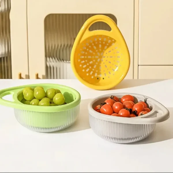 Green and grey colander sets with grapes and tomatoes, a yellow basket behind