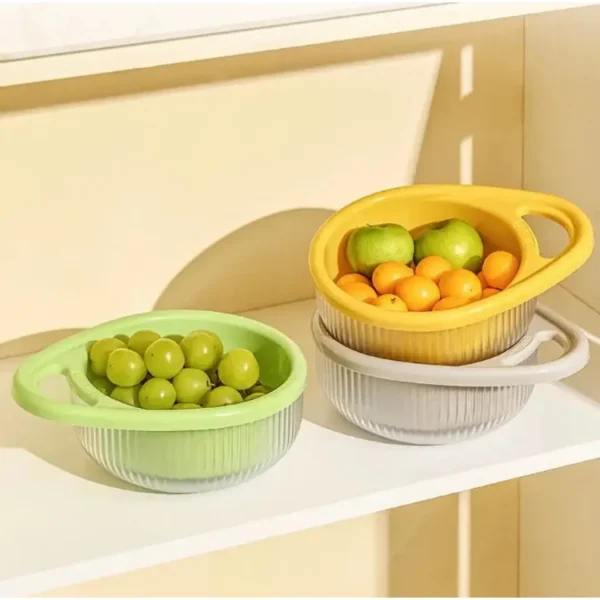 Green and yellow colander baskets holding grapes and oranges on a shelf