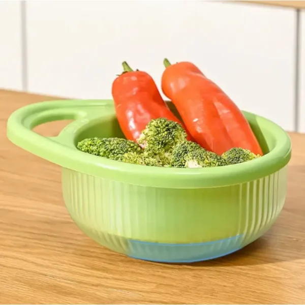 Green rice wash basket on a clear bowl holding broccoli and red peppers