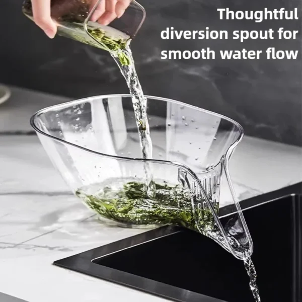 Clear plastic washing basket with a drain spout pouring water off leafy greens over a sink