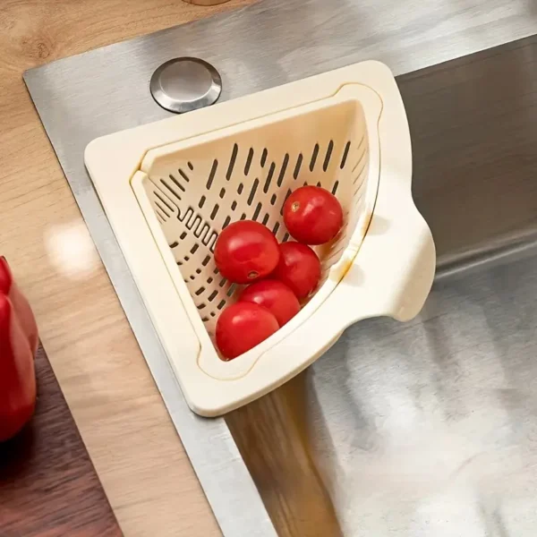 Cream triangular sink corner basket holding tomatoes in a steel sink