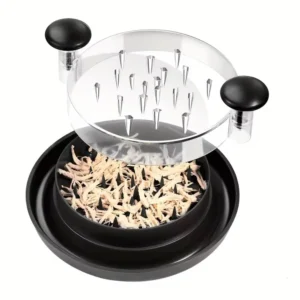 Manual meat shredder with the cover lifted above shredded chicken on a white background