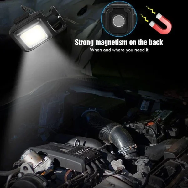 Mini LED flashlight keychain with a magnet on the back, lighting a car engine