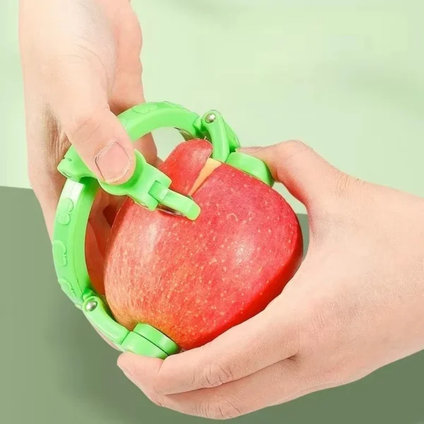 Hand holding a red apple with the green rotating apple peeler ring fitted and a strip of peel lifted