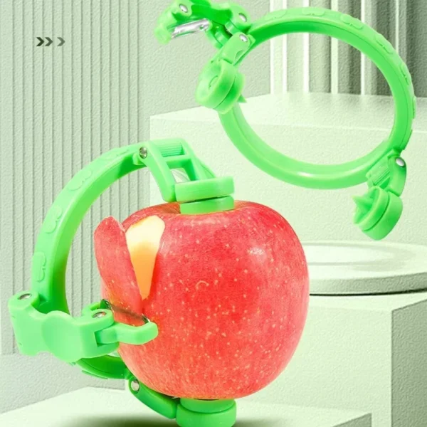Green rotating apple peeler ring peeling a red apple, with a second peeler ring beside it