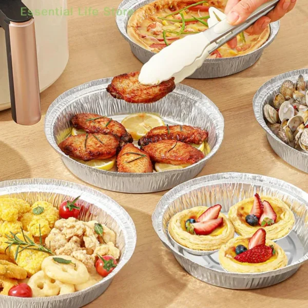 Round foil plates holding grilled meat, seafood and tarts on a table
