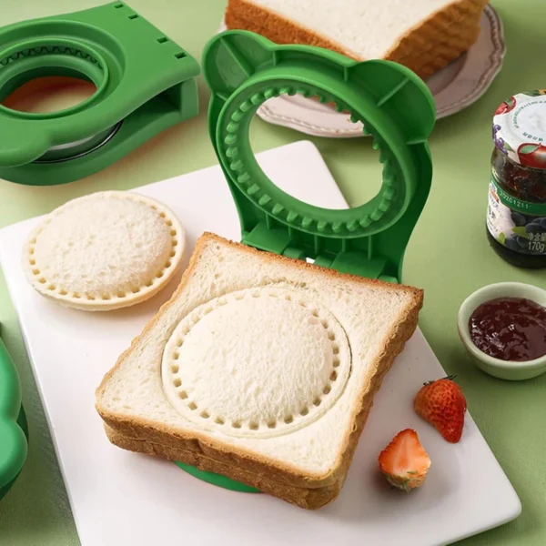 Green round sandwich cutter and sealer with a cut-out round sandwich beside a jar of jam