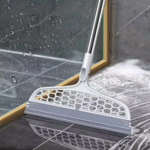 Silicone broom squeegee with a long handle pushing water across wet bathroom tiles