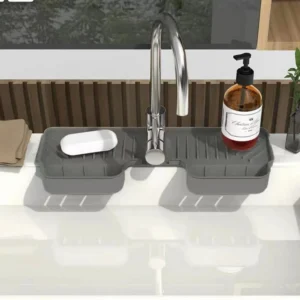 Grey silicone faucet tray with two baskets and a soap dish around a kitchen sink tap