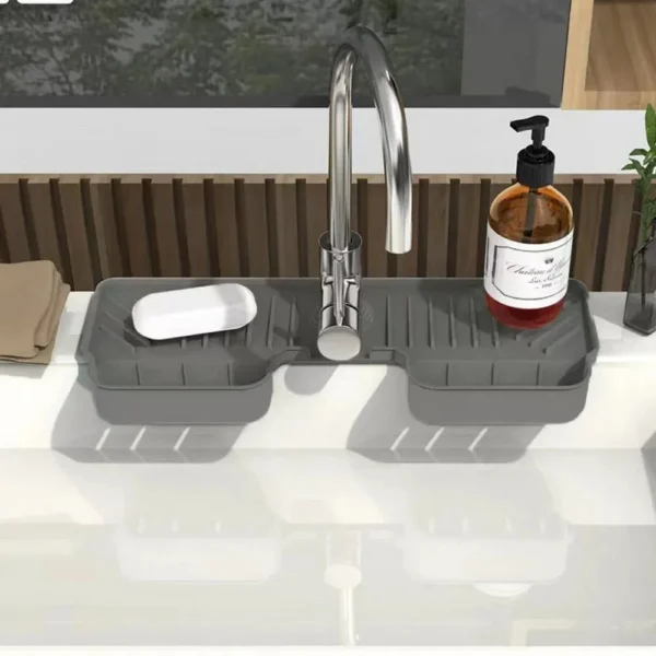 Grey silicone faucet tray with two baskets and a soap dish around a kitchen sink tap