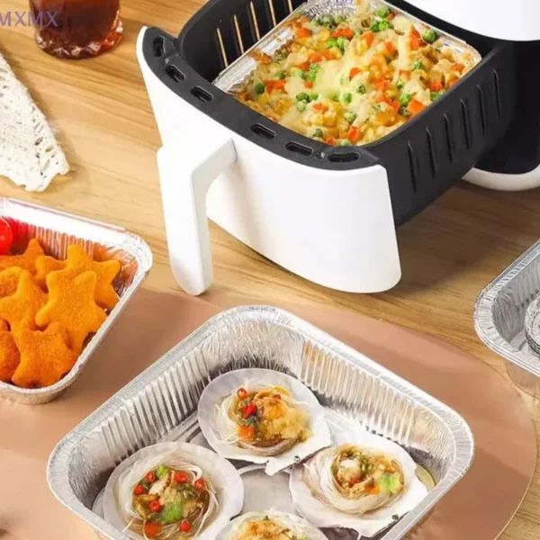Square foil tray with baked shells beside an air fryer