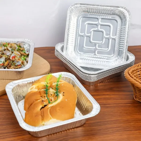 Stack of square foil plates with a bread roll served in one