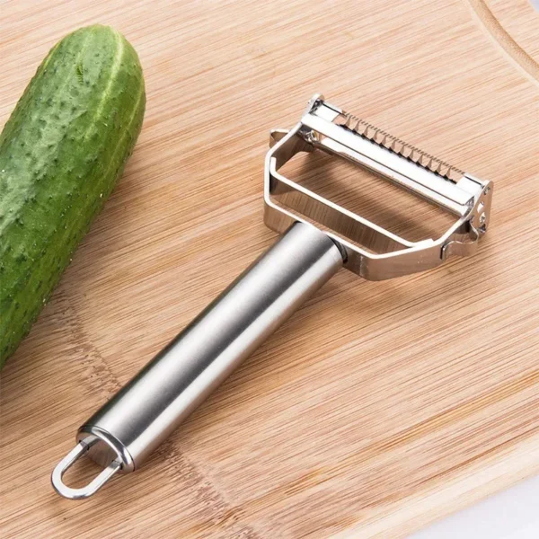 Stainless steel 4-in-1 vegetable peeler on a bamboo cutting board beside a cucumber