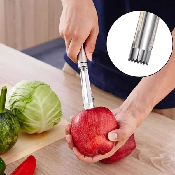 Hand pushing a stainless steel corer through a red apple on a chopping board