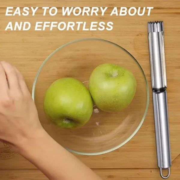 Stainless steel apple corer beside two green apples in a glass bowl
