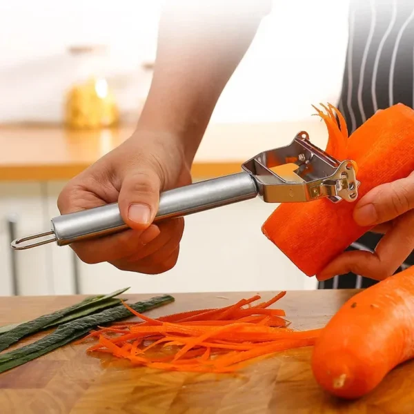 Stainless steel vegetable peeler making thin julienne strips from a carrot